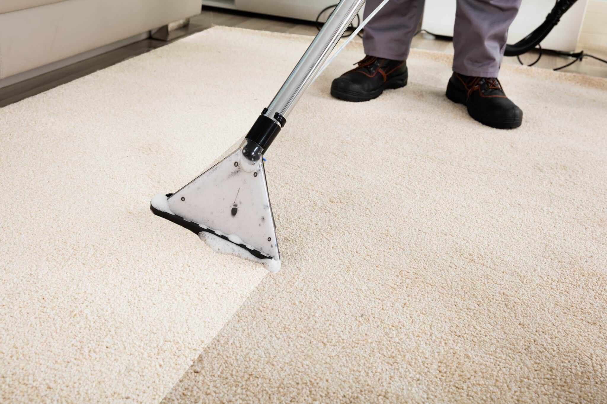 Person Cleaning Carpet With Vacuum Cleaner